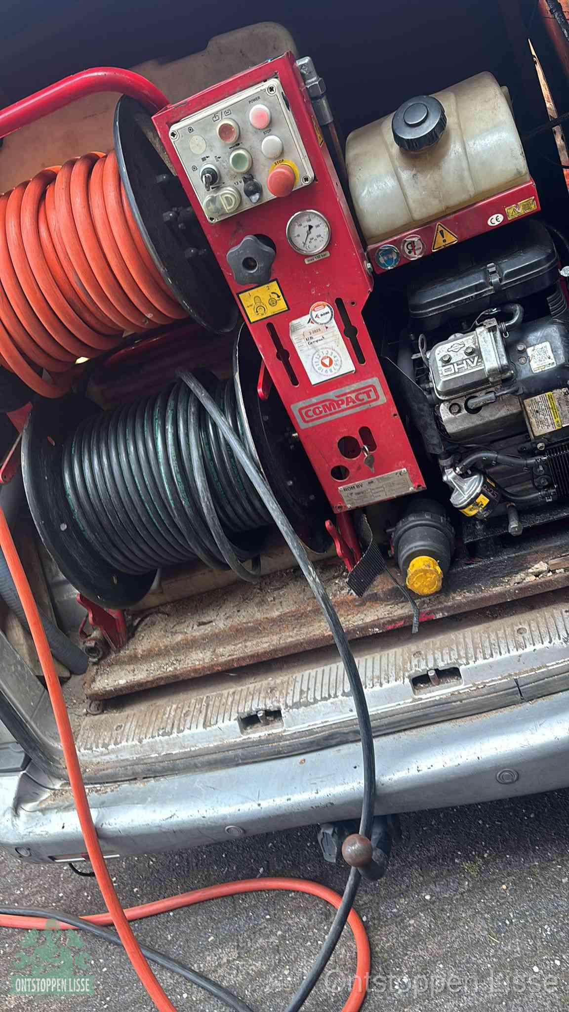 Een rood hogedruk-rioolreinigingstoestel in de laadbak van de bedrijfsbus, apparatuur voor een hardnekkige afvoerverstopping in Lisse