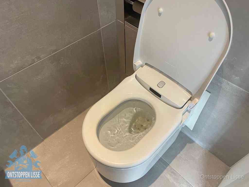 Een toiletpot vol troebel water met drijvend papier en restanten, de meest voorkomende oorzaak van een verstopte wc in Lisse