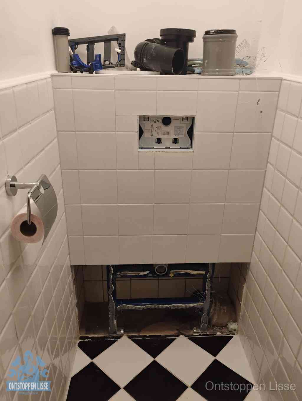 Een toiletruimte waar het hangtoilet en de inbouwreservoir-onderdelen zijn vrijgelegd voor onderhoud, periodiek nazicht voorkomt een wc-verstopping in Lisse